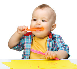 Image showing Happy little boy is playing with colorful markers