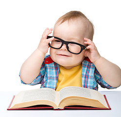 Image showing Little child play with book and glasses