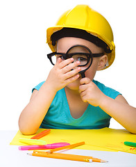 Image showing Cute little girl is looking through magnifier