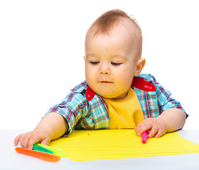 Image showing Happy little boy is playing with colorful markers