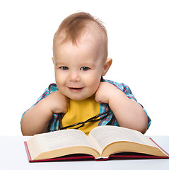 Image showing Little child play with book and glasses