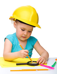Image showing Cute little girl is playing while wearing hard hat