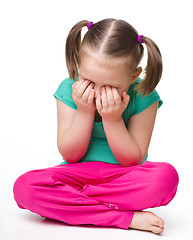 Image showing Little girl is sitting on floor and crying