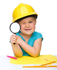 Image showing Cute little girl is looking through magnifier