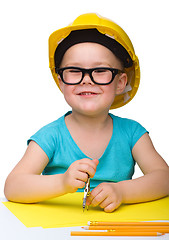 Image showing Little girl is playing while wearing hard hat