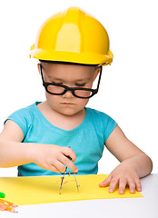 Image showing Little girl is playing while wearing hard hat