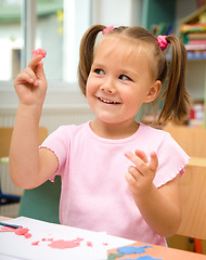 Image showing Little girl is playing with plasticine