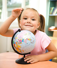 Image showing Little girl is playing with globe