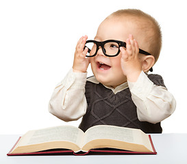 Image showing Little child play with book and glasses
