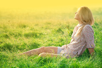 Image showing Girl is relaxing on green field