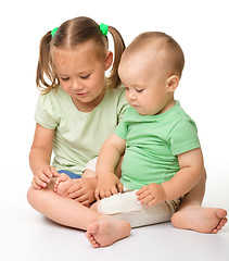 Image showing Two children are playing on the floor