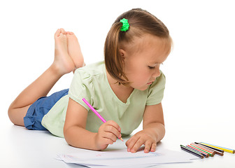 Image showing Little girl is drawing while laying on the floor
