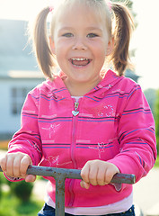 Image showing Cute little girl is swinging on see-saw