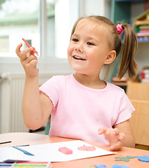 Image showing Little girl is playing with plasticine