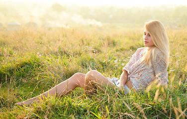 Image showing Girl is relaxing on green field
