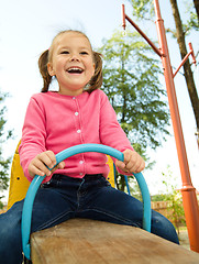 Image showing Cute little girl is swinging on see-saw