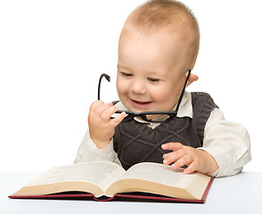 Image showing Little child play with book and glasses