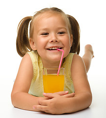 Image showing Little girl drinks orange juice