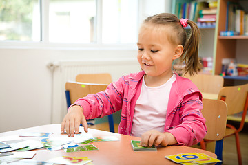 Image showing Cute little girl is playing with educational cards