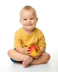 Image showing Cheerful little boy with red apple