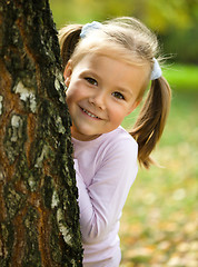 Image showing Little girl is playing in autumn park