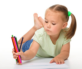 Image showing Little girl is drawing while laying on the floor