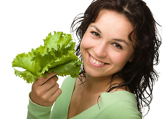 Image showing Beautiful young girl with green lettuce leaf