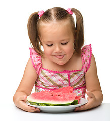 Image showing Cute little girl is going to eat watermelon