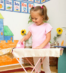 Image showing Little girl is playing with iron