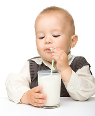 Image showing Cute little boy is drinking milk