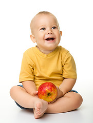 Image showing Cheerful little boy with red apple