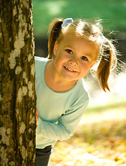 Image showing Little girl is playing in autumn park