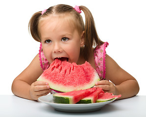 Image showing Cute little girl is going to eat watermelon