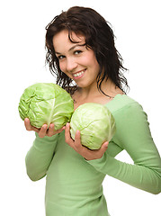 Image showing Beautiful young girl with two green cabbages