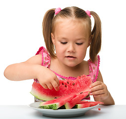 Image showing Cute little girl is going to eat watermelon