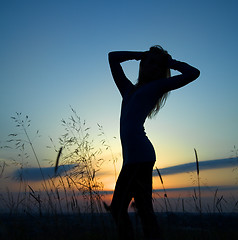 Image showing Silhouette of a girl over sunset