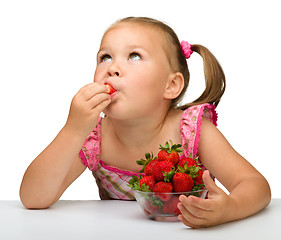 Image showing Happy little girl eats strawberries