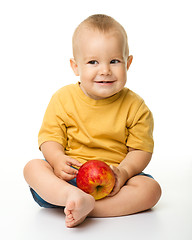 Image showing Cheerful little boy with red apple