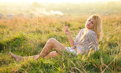 Image showing Girl is relaxing on green field