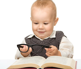 Image showing Little child play with book and glasses