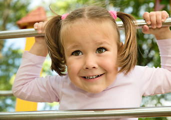 Image showing Little girl is playing in playground