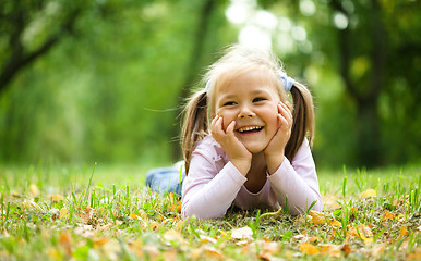 Image showing Little girl is playing in autumn park