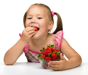 Image showing Happy little girl eats strawberries