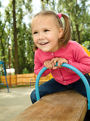 Image showing Cute little girl is swinging on see-saw