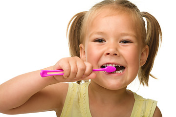 Image showing Little girl is cleaning teeth using toothbrush