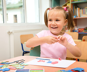 Image showing Little girl is playing with plasticine