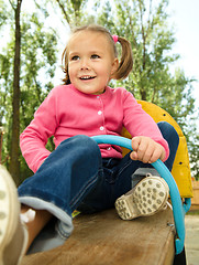 Image showing Cute little girl is swinging on see-saw