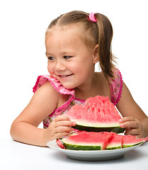 Image showing Cute little girl is going to eat watermelon