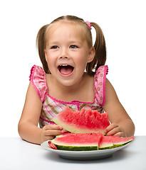 Image showing Cute little girl is going to eat watermelon