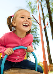 Image showing Cute little girl is swinging on see-saw